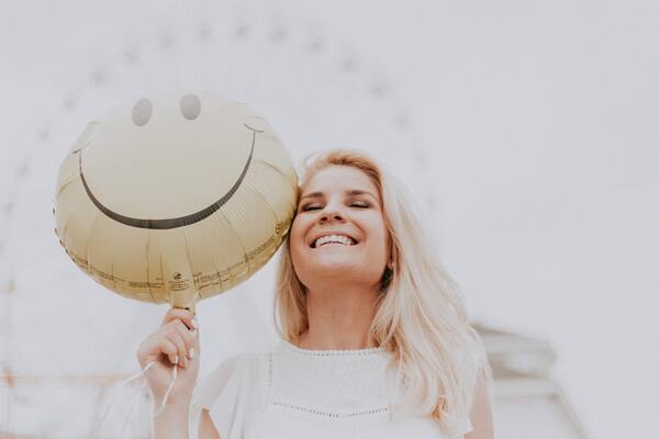 Femme tenant un ballon smiley